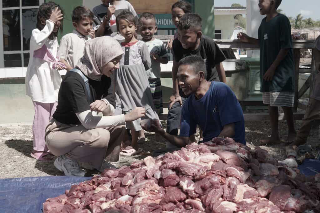 Nabila Ishma turut membantu warga Desa Papela memotong dan mengepak daging-daging kurban untuk dibagikan kepada warga sekitar.