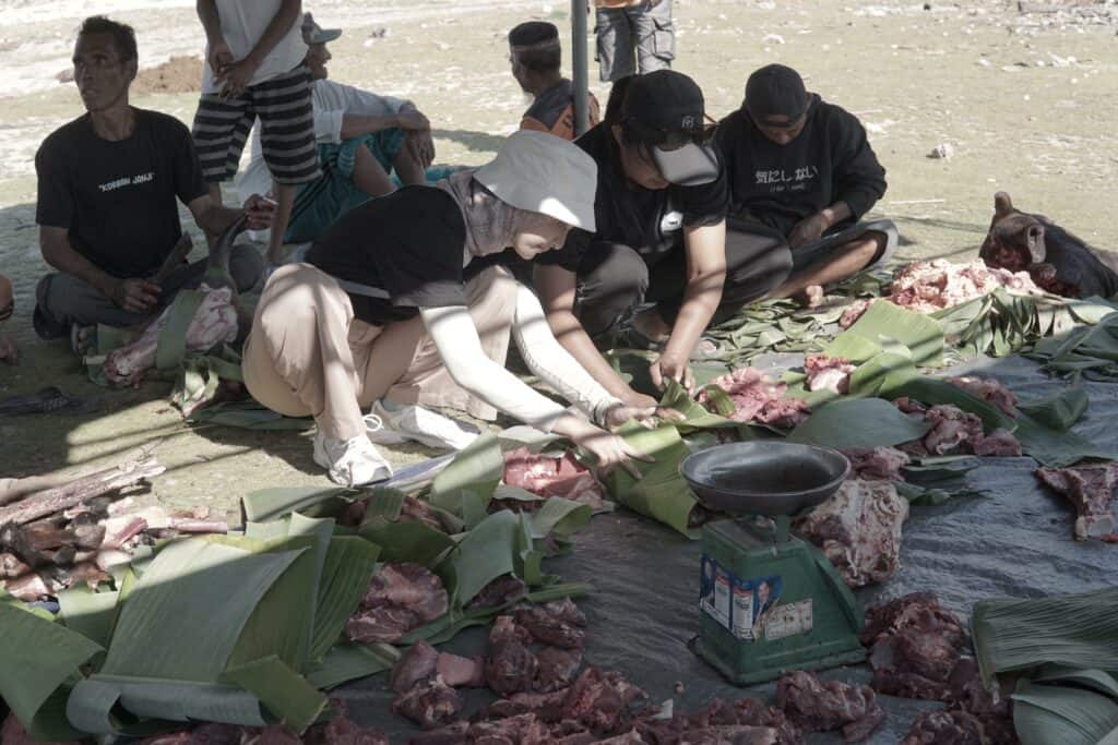 Nabila Ishma turut membantu warga Desa Papela memotong dan mengepak daging-daging kurban untuk dibagikan kepada warga sekitar.