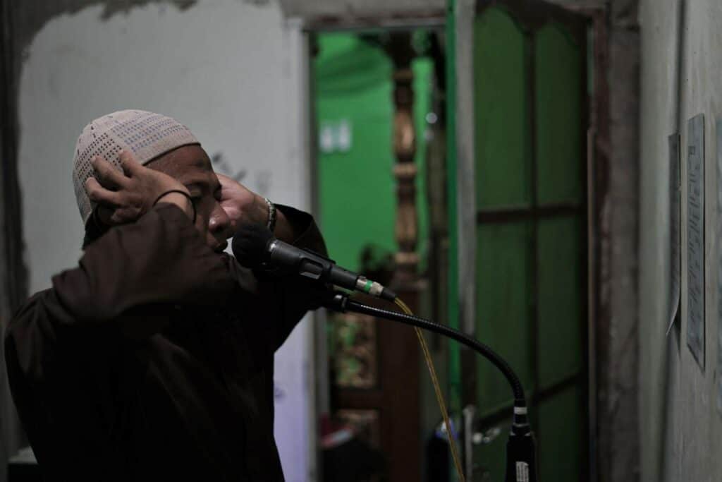 Busron Daeng Kawang melakukan adzan di Masjid Al Muhajirin Manyumbeng (masjid sekitar dekat tempat tinggalnya sekarang di wilayah Kelurahan Biringkassi, Kecamatan Binamu, Jeneponto) saat masuk waktu ibadah solat.