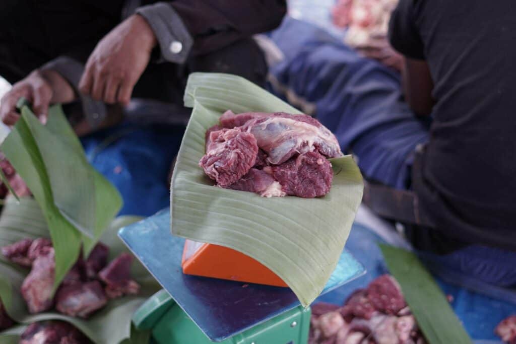 Proses penimbangan dan pembungkusan daging kurban untuk dibagikan kepada warga yang membutuhkan.