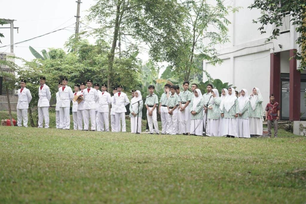 Petugas pengibaran bendera (sebelah kiri) adalah siswa-siswa SMART Ekselensia Indonesia, sementara kelompok paduan suara (sebelah kanan) merupakan siswa-siswi Al Syukro Universal.