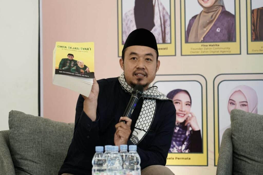 Ahmad Fauzi Qosim selaku Moderator dalam kajian Prof. Dr. H. Muhammad Amin Suma, S.H., menunjukkan buku “Cinta Sejati Syar'i: 41 Tahun Pernikahan Mas & Khol”.