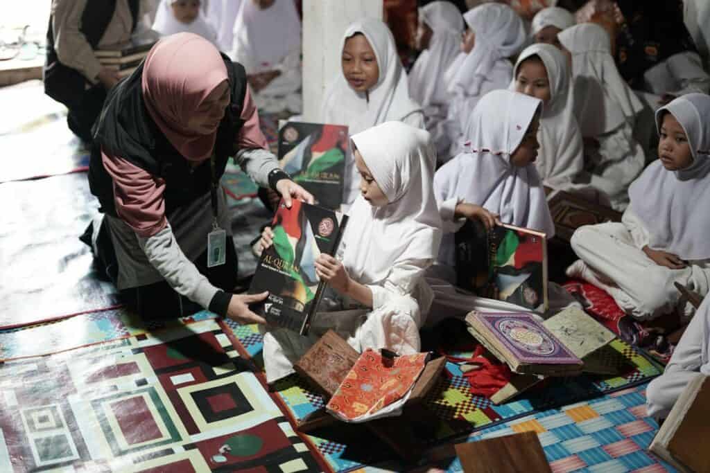 Tim Dompet Dhuafa membagikan mushaf Al-Qur’an baru kepada santri-santri TPA Nurus Salam Desa Ulak sebagai pengganti Al-Qur’an mereka yang sudah kusut.