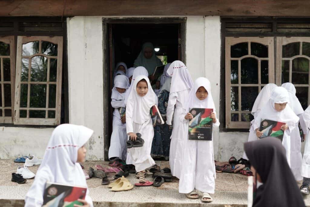 Para santri TPA Nurus Salam pulang dari kegiatan belajar mengajar dengan membawa mushaf Al-Qur’an baru pemberian dari donatur Dompet Dhuafa.