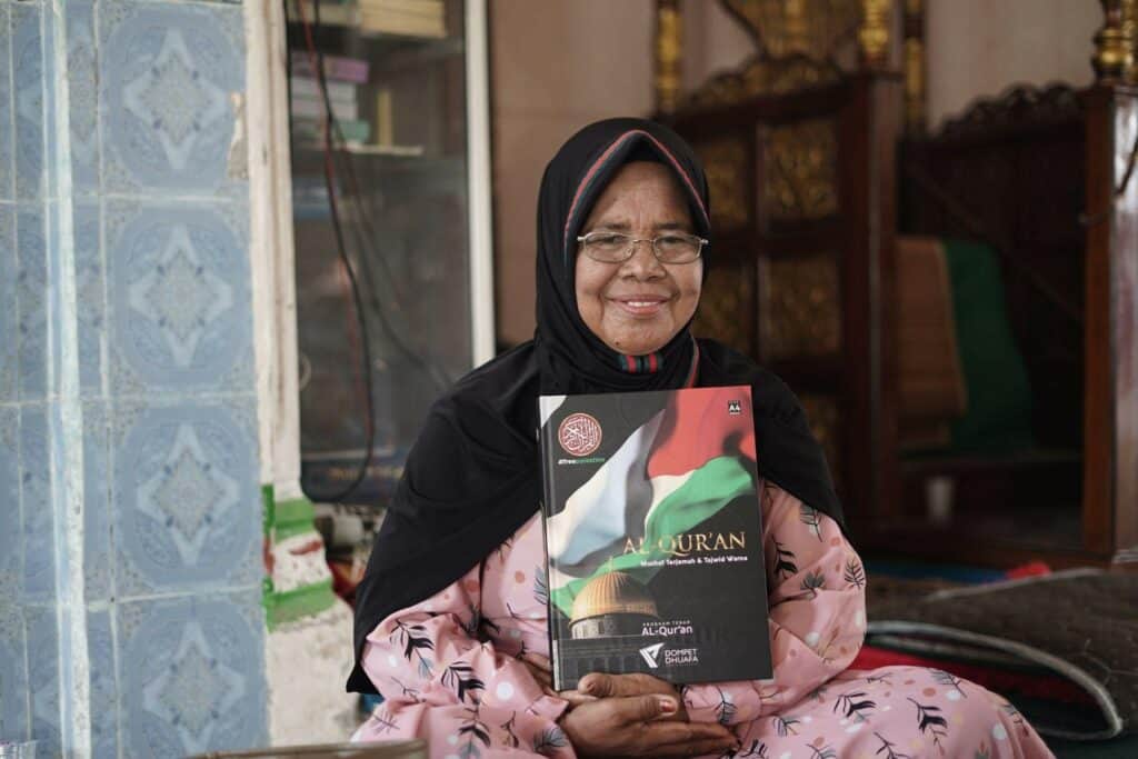 Aminah menerima Mushaf Al-Qur’an baru pemberian dari donatur Dompet Dhuafa.