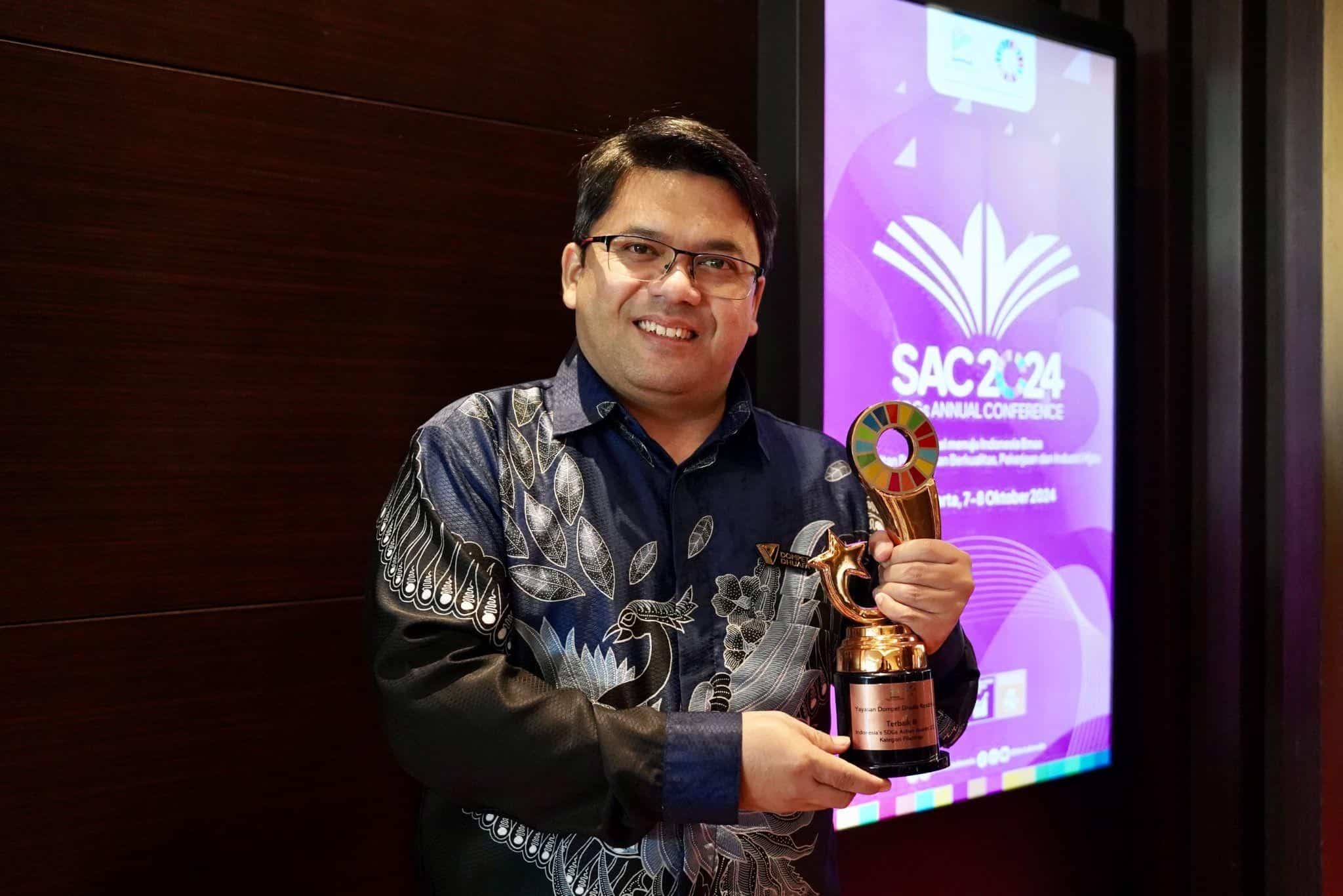 Direktur Institut Kemandirian, Abdurrahman Usman berswafoto dengan Penghargaan ‘Indonesia’s SDGs Action Awards 2024 - Terbaik Ketiga dalam Kategori Filantropi’ untuk program Institut Kemandirian Dompet Dhuafa dalam SDGs Annual Conference (SAC) ke-7 di Hotel Fairmont, Jakarta Pusat, Senin (07/10/2024).