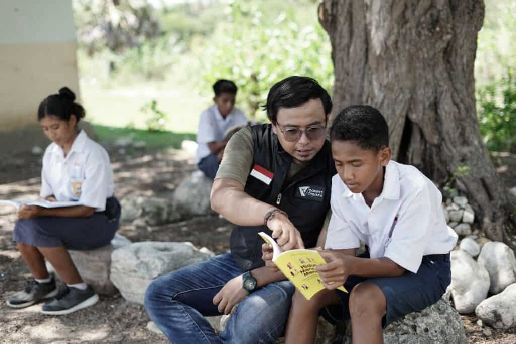 Hasairi Arnas (kedua-kanan) membaca bersama siswa-siswi SMPN Kletek di bawah pohon baca.