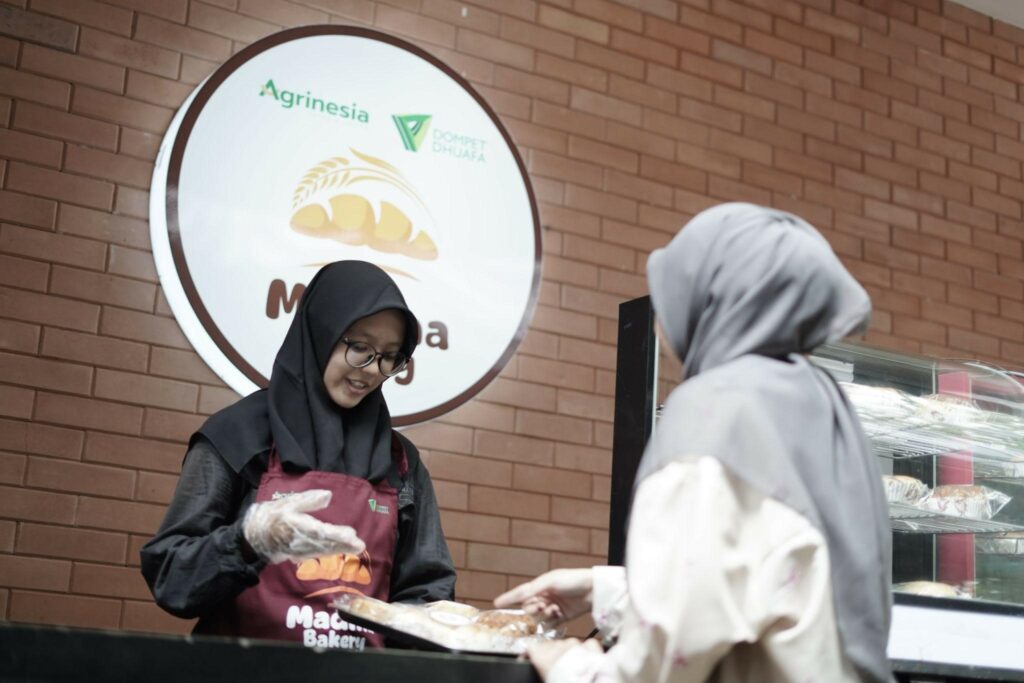 Salah satu karyawan Madina Bakery, yang juga adalah penerima manfaat program, sedang melayani pelanggan di Zona Madina, Parung, Bogor, Senin (23/12/2024).